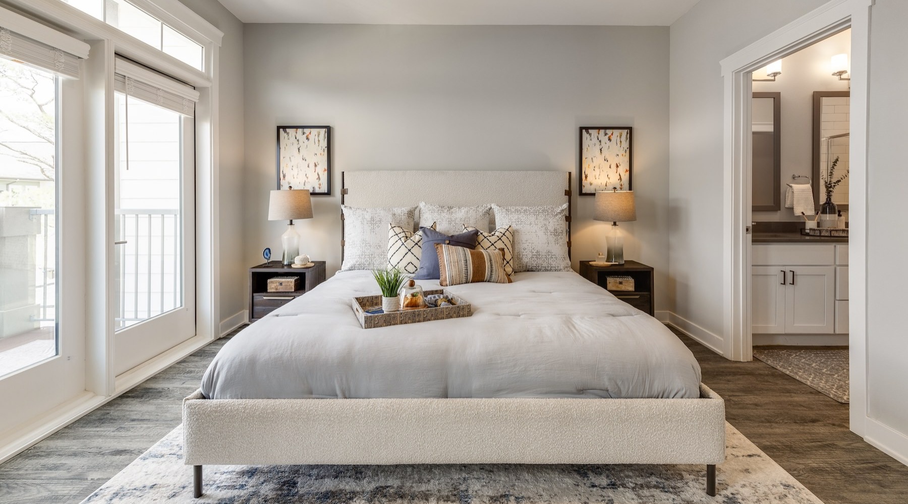bedroom with nightstands on each side of the bed and large windows